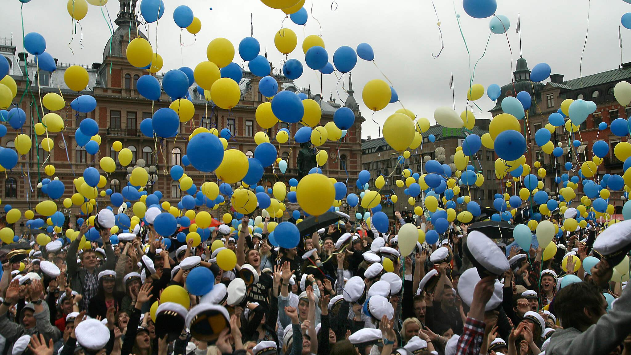 Mösspåtagning för Sundsvalls studenter på Stora torget i Sundsvall. Hundratals gula och blå ballonger svävar över ett folkhav av studenter.